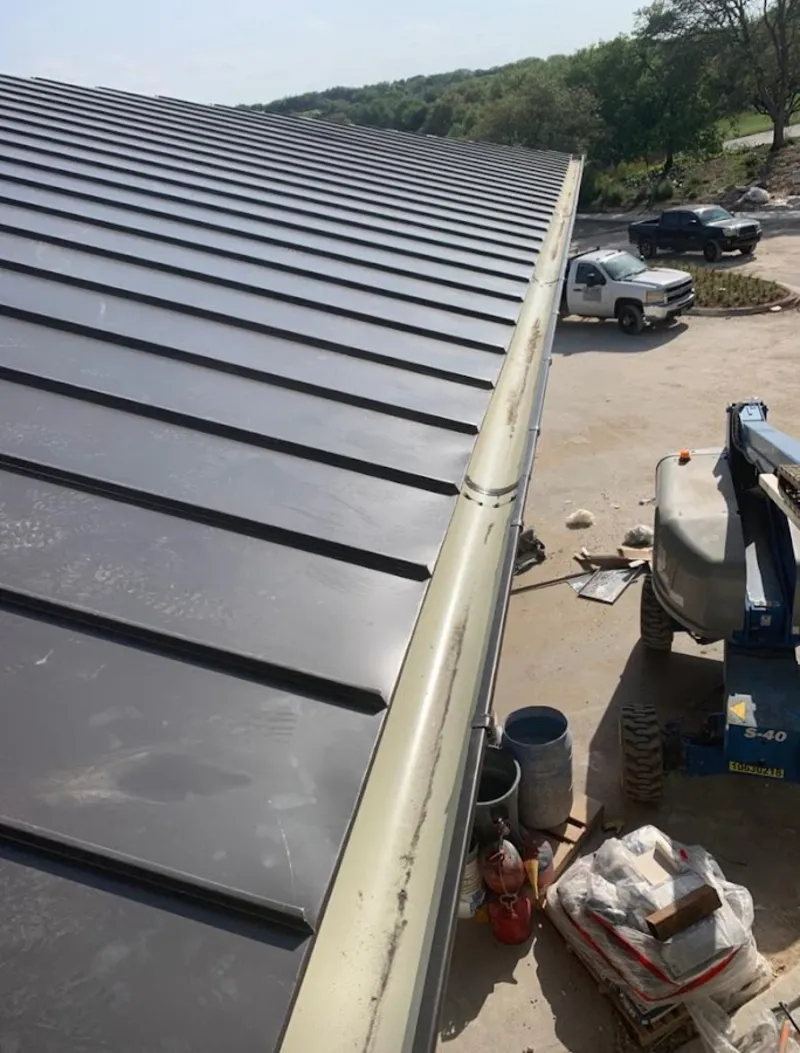Standing seam panel and gutter detail on a metal roofing jobsite in Independence